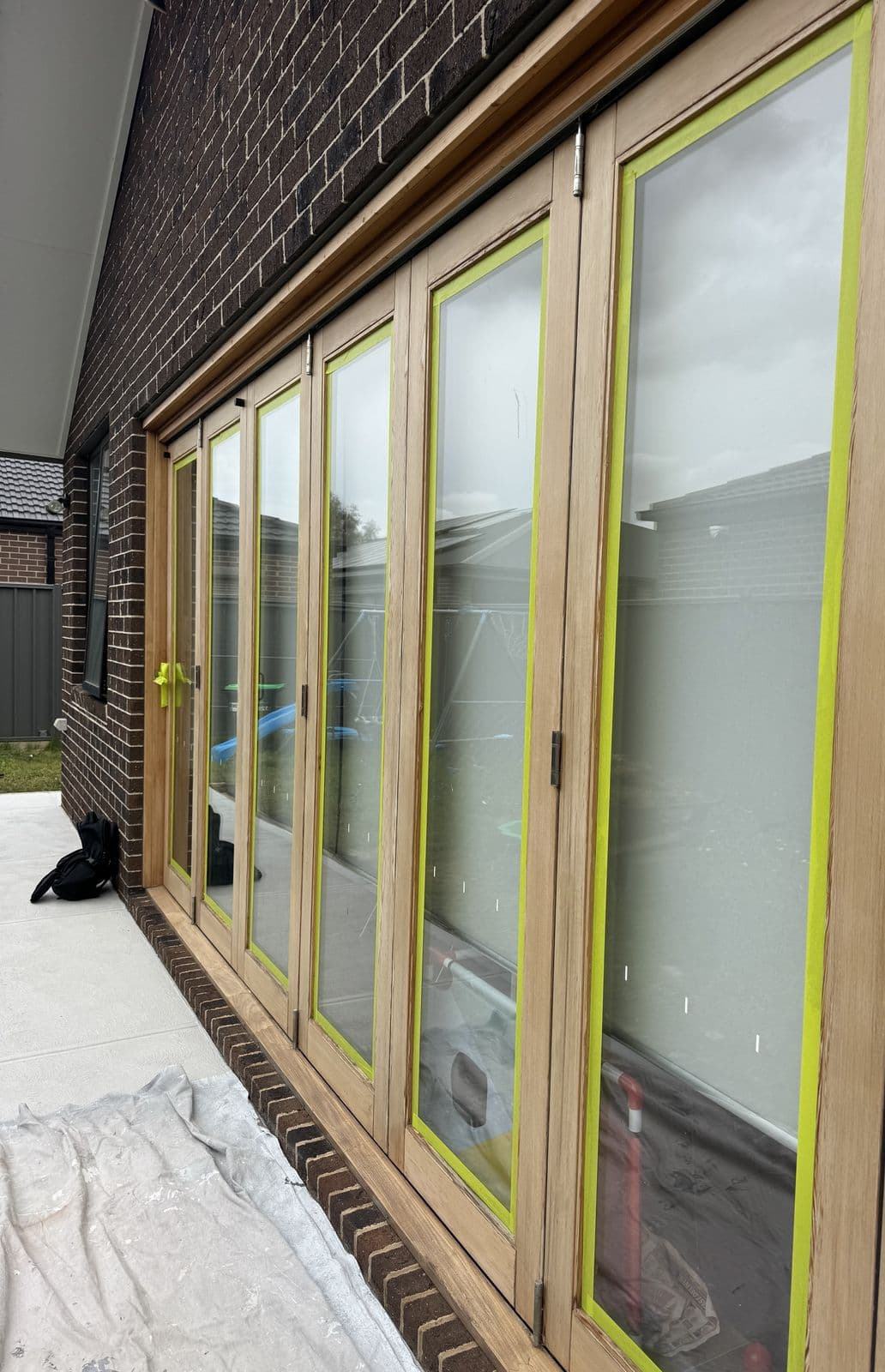 Before: bare timber bifold doors masked with tape, ready for painting